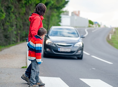 18256202 - mother and son passing a street when a car coming